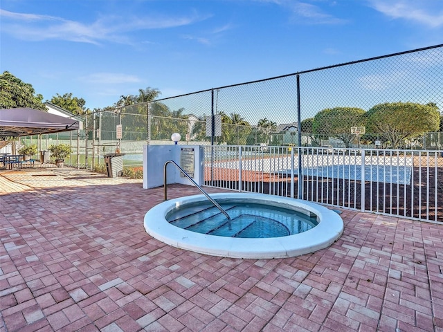 view of swimming pool with a community hot tub and fence