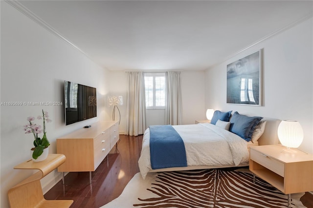 bedroom with dark hardwood / wood-style floors and crown molding