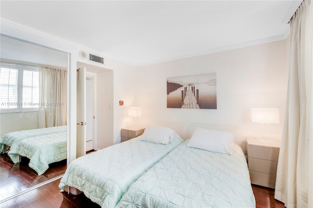 bedroom featuring dark hardwood / wood-style floors and crown molding