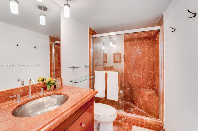 bathroom with tile patterned floors, vanity, toilet, and a shower with door