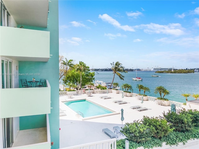 view of swimming pool with a water view and a patio