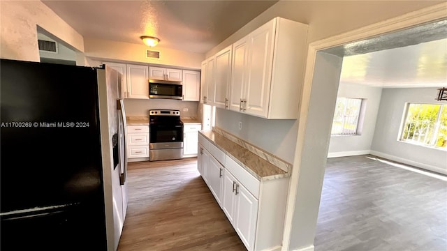 kitchen with white cabinets, dark hardwood / wood-style floors, and appliances with stainless steel finishes