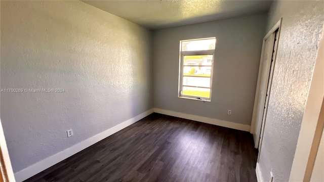 spare room with dark hardwood / wood-style floors