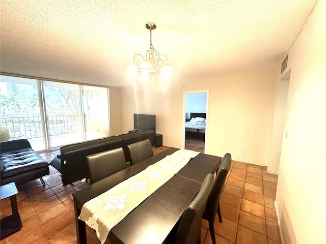 dining area featuring a textured ceiling, an inviting chandelier, and dark tile patterned floors