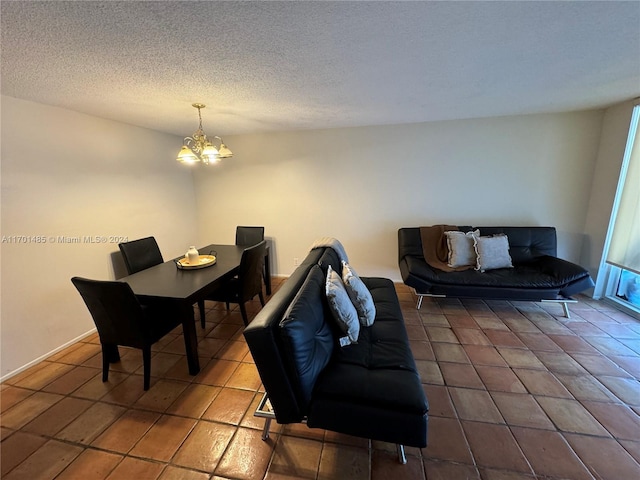 living room featuring a textured ceiling, dark tile patterned floors, and a notable chandelier