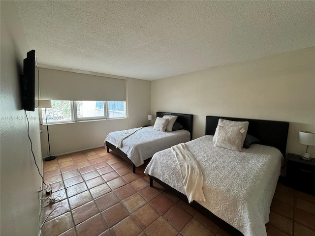 tiled bedroom featuring a textured ceiling