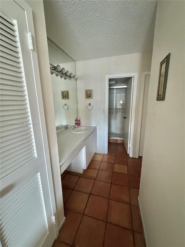 bathroom with tile patterned floors, vanity, and a textured ceiling