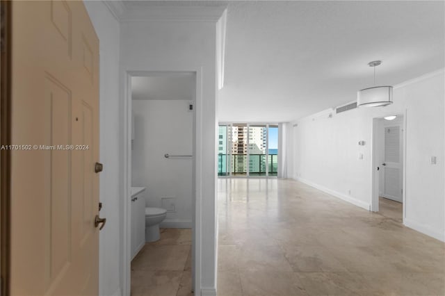 hallway with floor to ceiling windows and ornamental molding