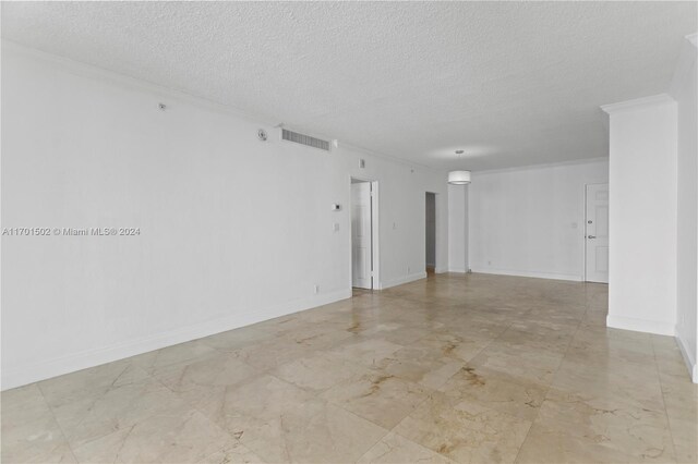 spare room featuring a textured ceiling and ornamental molding