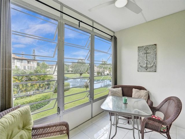 sunroom / solarium featuring a water view and ceiling fan