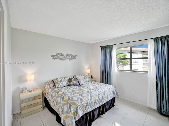 bedroom featuring light tile patterned floors and a textured ceiling