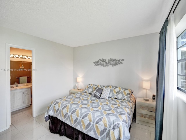 tiled bedroom with connected bathroom and a textured ceiling