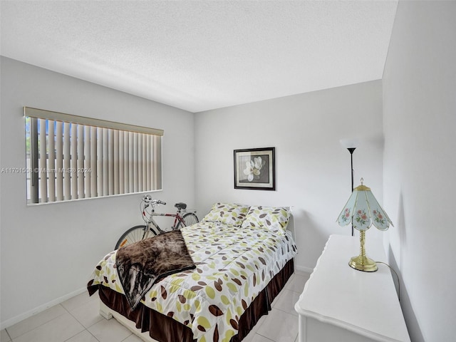 bedroom featuring light tile patterned flooring and a textured ceiling