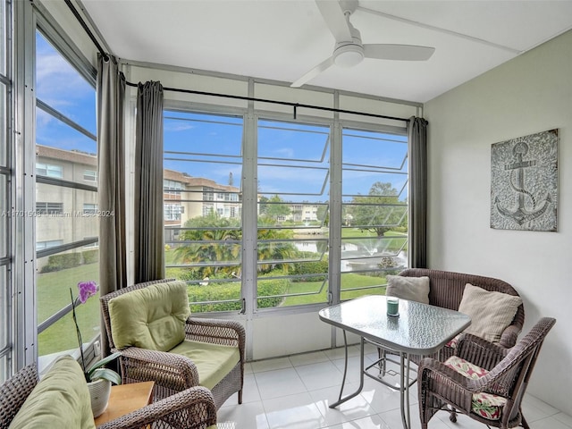 sunroom / solarium with a water view and ceiling fan