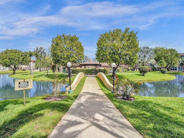 view of property's community with a gazebo, a lawn, and a water view