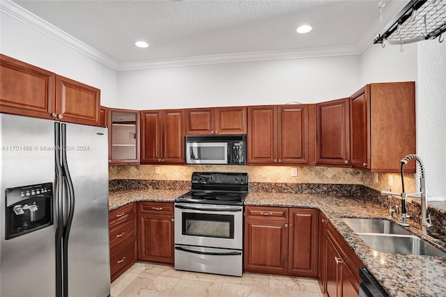 kitchen featuring sink, backsplash, dark stone counters, appliances with stainless steel finishes, and ornamental molding