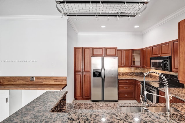 kitchen with sink, ornamental molding, dark stone counters, and appliances with stainless steel finishes