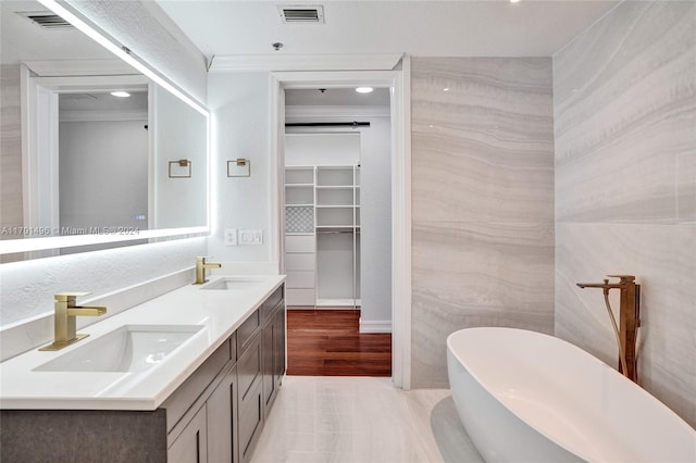 bathroom with vanity, crown molding, a washtub, tile walls, and wood-type flooring