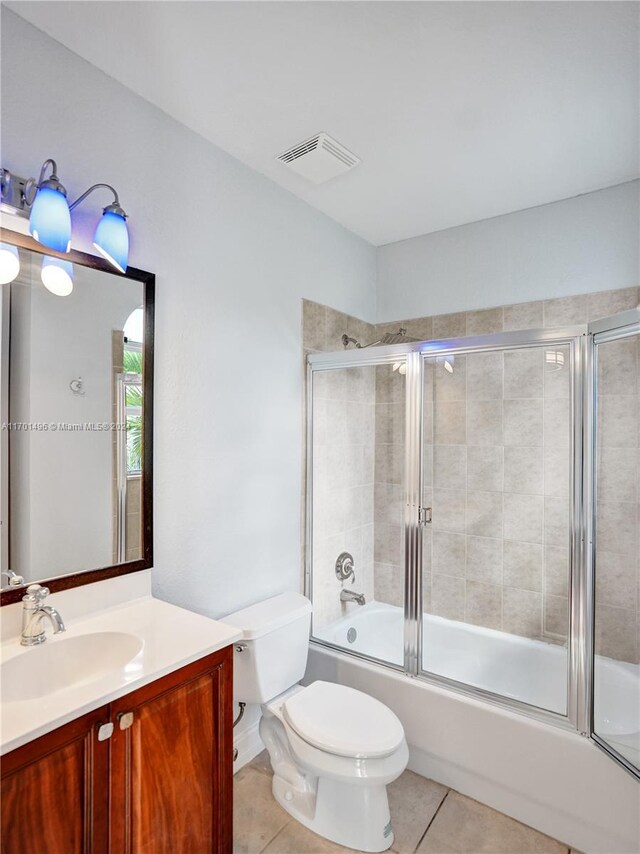 full bathroom with tile patterned floors, vanity, enclosed tub / shower combo, and toilet