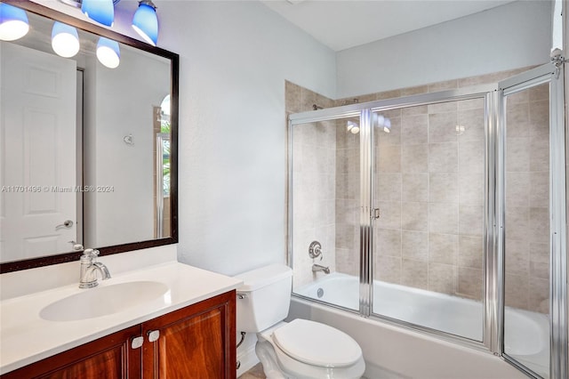 full bathroom featuring vanity, toilet, and combined bath / shower with glass door