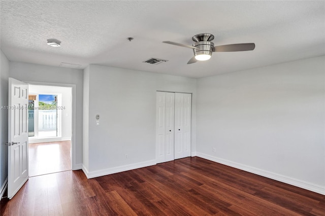 unfurnished bedroom with a textured ceiling, a closet, dark hardwood / wood-style floors, and ceiling fan