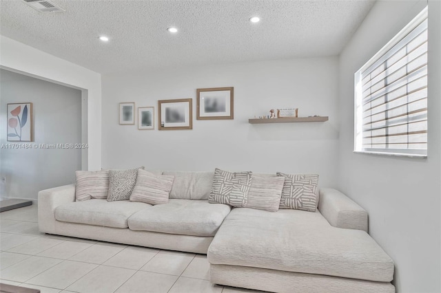 tiled living room featuring a textured ceiling