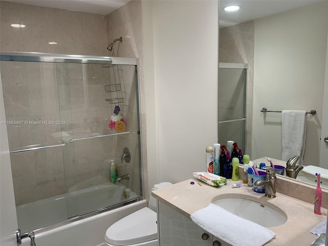 full bathroom featuring vanity, toilet, and bath / shower combo with glass door