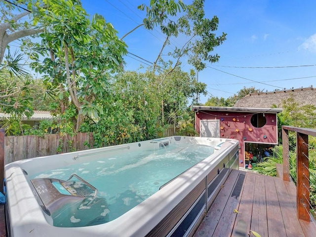 wooden deck with a hot tub