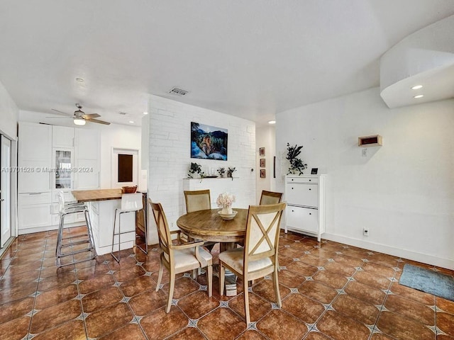 dining space featuring dark tile patterned floors and ceiling fan