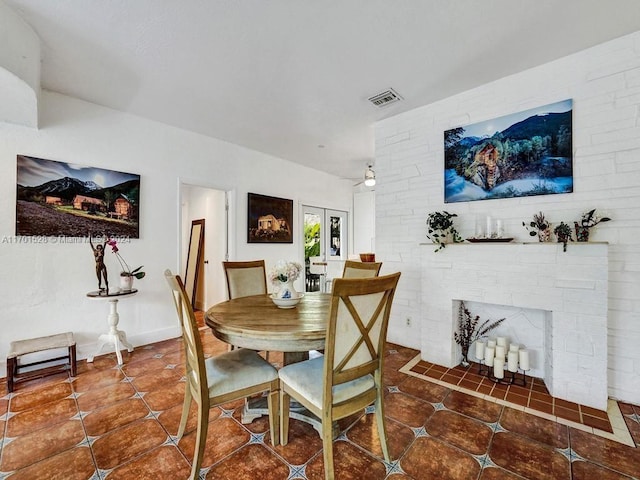 dining space with ceiling fan, french doors, and dark tile patterned flooring