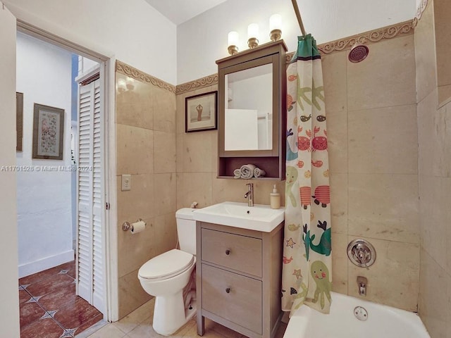 full bathroom with vanity, tile patterned floors, toilet, tile walls, and shower / tub combo