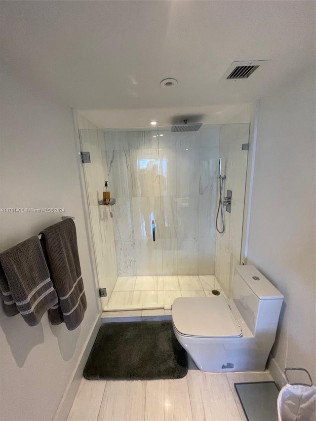 bathroom with tile patterned floors, toilet, and an enclosed shower