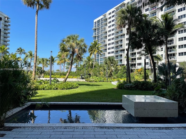 view of home's community with a water view and a yard