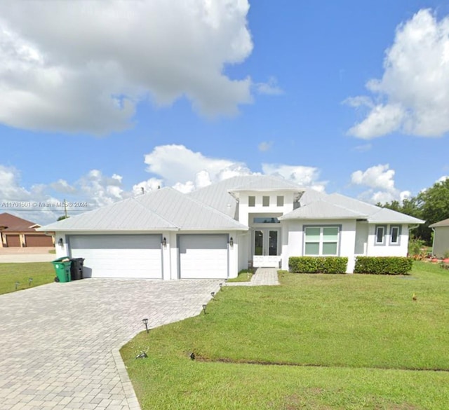 view of front facade with french doors, a front yard, and a garage