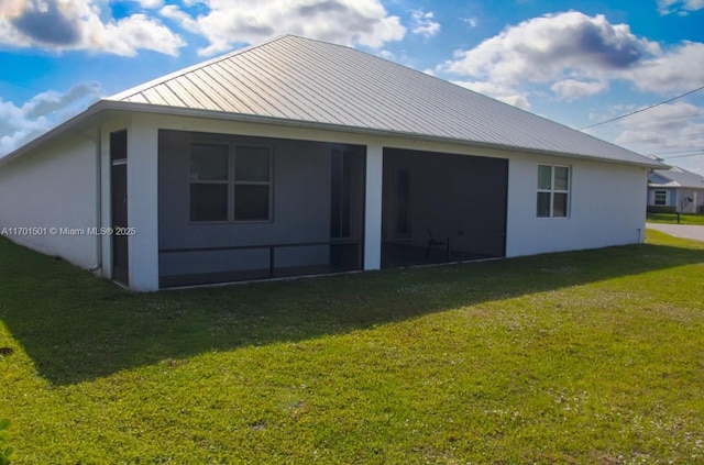 5231 NW Iredell St, Port St Lucie, FL 34986 - rear view of property featuring a standing seam roof, a lawn, metal roof, and a sunroom