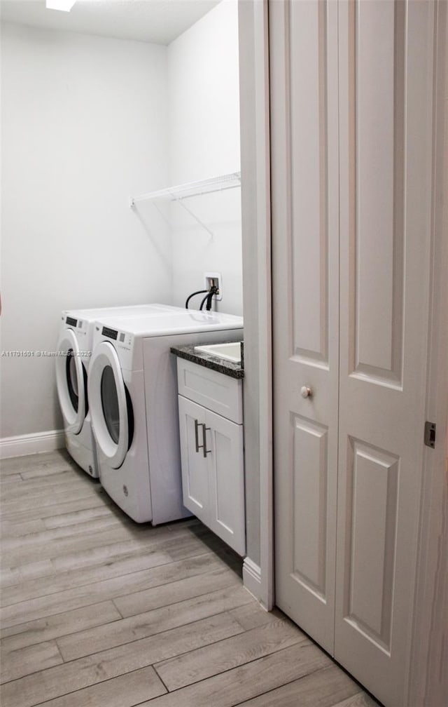 5231 NW Iredell St, Port St Lucie, FL 34986 - clothes washing area featuring cabinet space, independent washer and dryer, light wood-type flooring, and baseboards