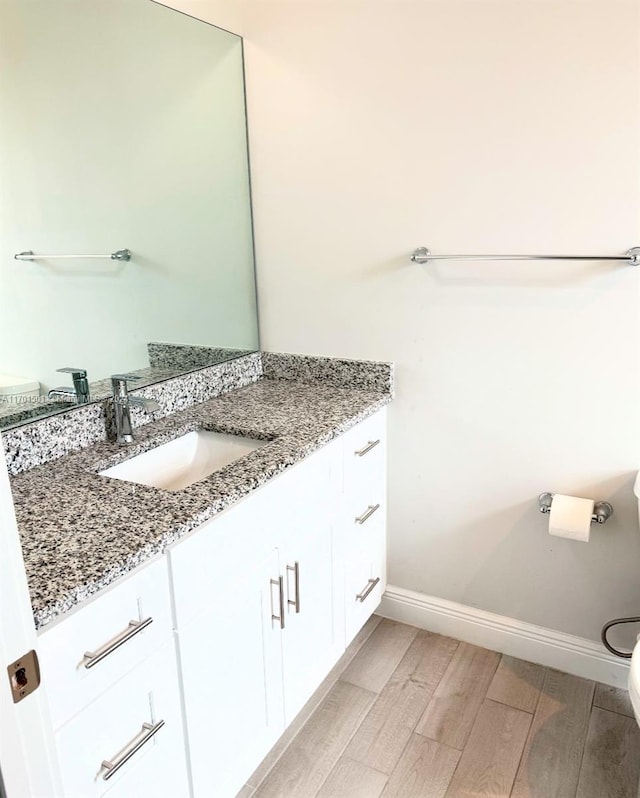 bathroom with vanity, hardwood / wood-style flooring, and toilet