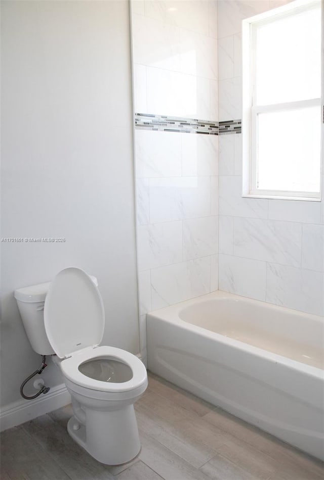 5231 NW Iredell St, Port St Lucie, FL 34986 - full bathroom with toilet, wood finished floors, and washtub / shower combination