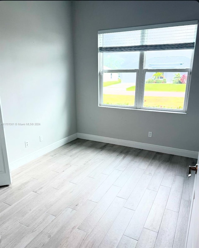 unfurnished room featuring light wood-type flooring and plenty of natural light