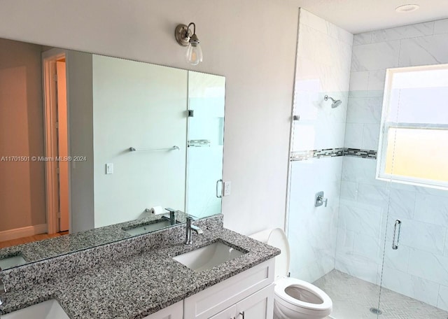 bathroom featuring vanity, a shower with shower door, and toilet