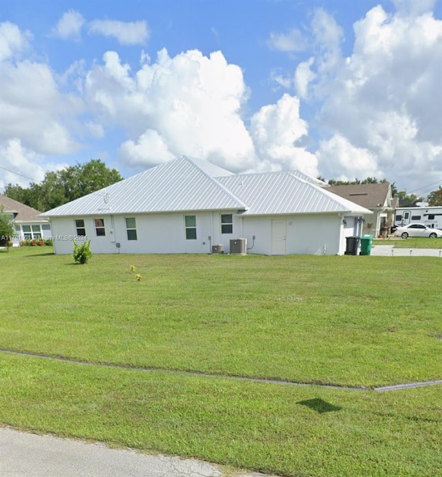 view of front of home featuring central AC and a front lawn