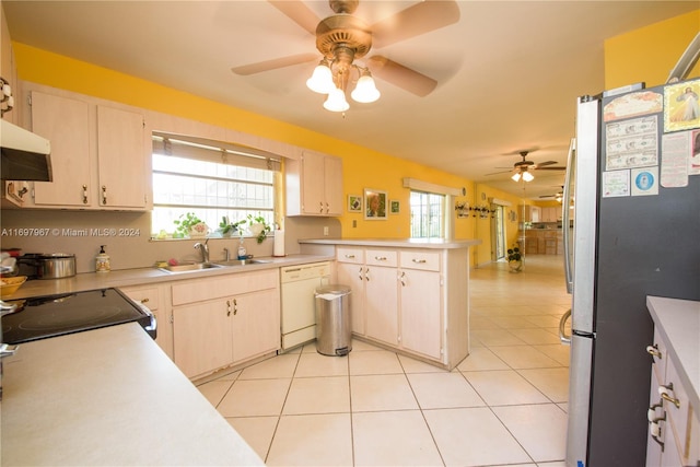 kitchen featuring dishwasher, a healthy amount of sunlight, sink, and stainless steel refrigerator