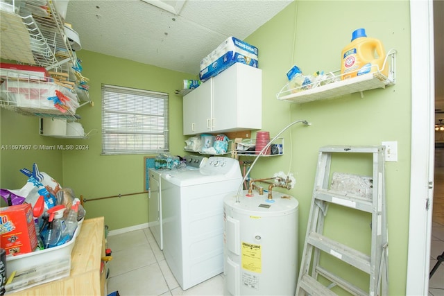 laundry area with cabinets, electric water heater, a textured ceiling, light tile patterned floors, and washer and dryer