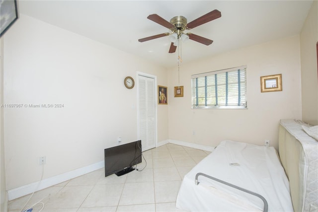 bedroom featuring ceiling fan, a closet, and light tile patterned flooring