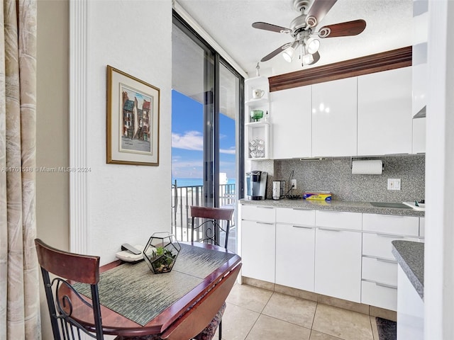 kitchen featuring white cabinets, decorative backsplash, ceiling fan, a textured ceiling, and light tile patterned flooring