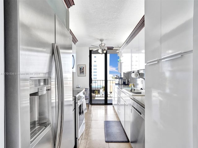 kitchen featuring floor to ceiling windows, ceiling fan, white cabinets, and appliances with stainless steel finishes