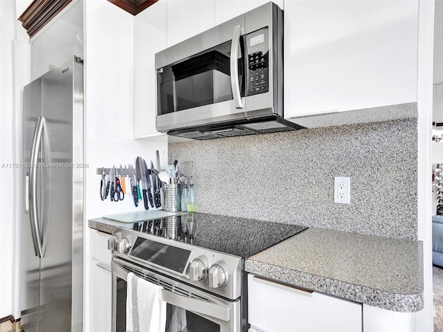 kitchen featuring white cabinets, stainless steel appliances, and tasteful backsplash