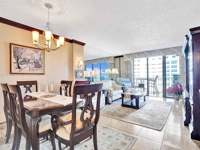 dining space featuring light tile patterned floors, a chandelier, a textured ceiling, and ornamental molding