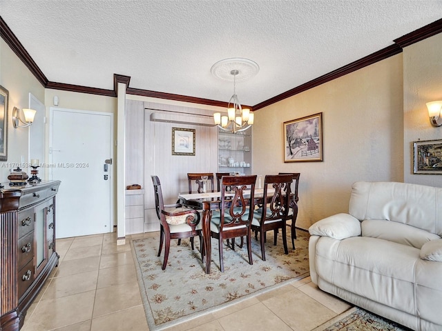 tiled dining space with an inviting chandelier, a textured ceiling, and ornamental molding