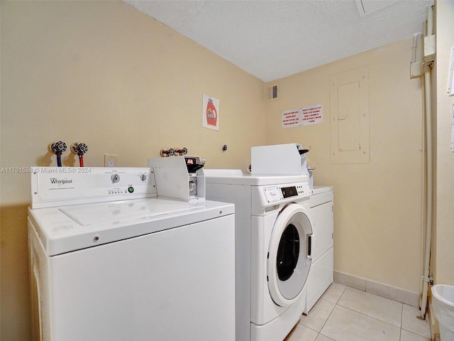 laundry area with separate washer and dryer, electric panel, light tile patterned flooring, and a textured ceiling